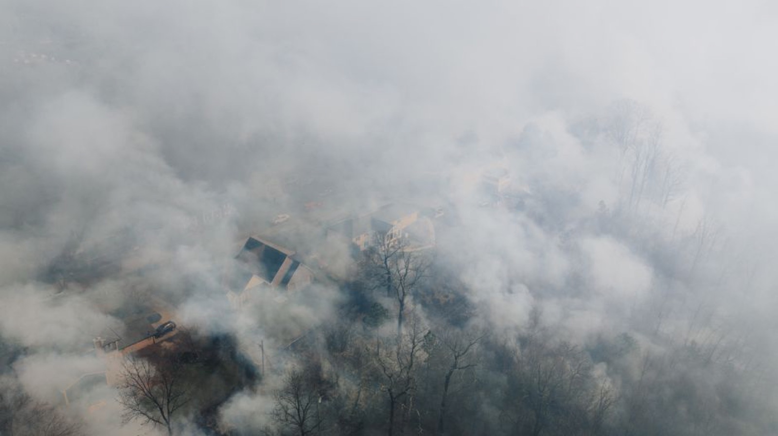 Aerial view of a neighborhood shrouded in wildfire smoke haze