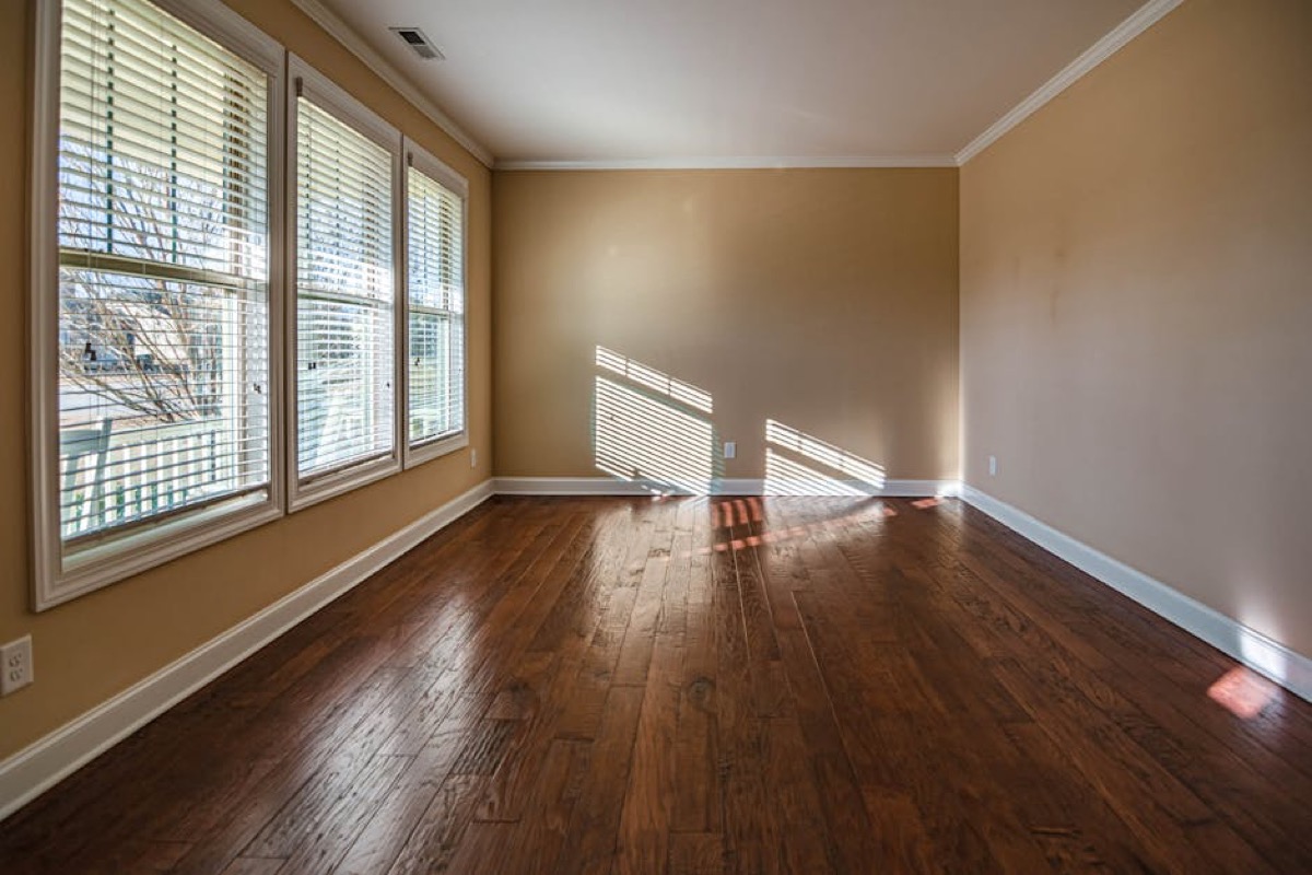 Large open living room with hardwood floors and windows
